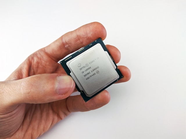 Hand holding an Intel CPU.