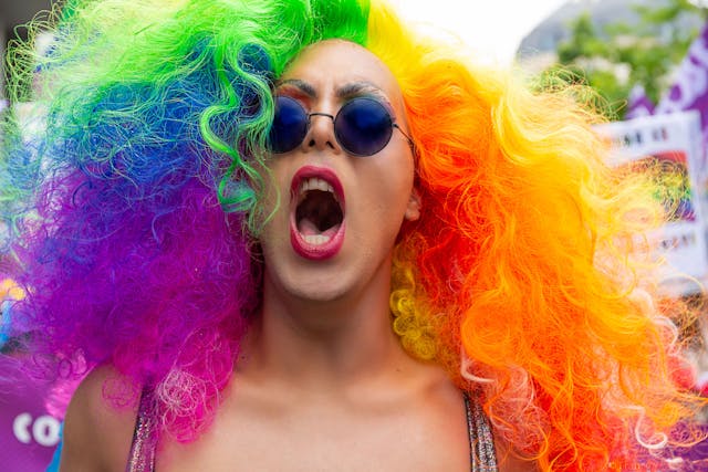 A woman with colorful hair shouting. 