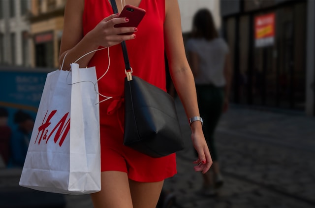 Lady holding a bag with an H&M logo on it. 