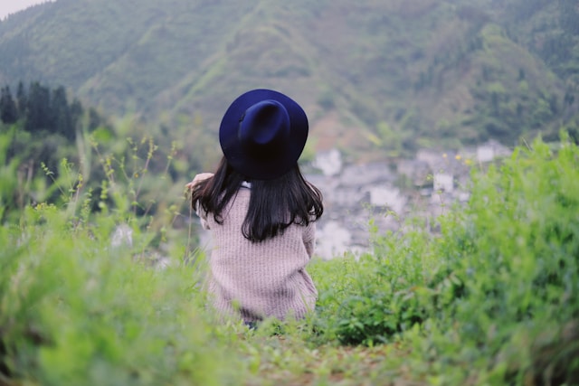 A woman with her face hidden by a large hat. 