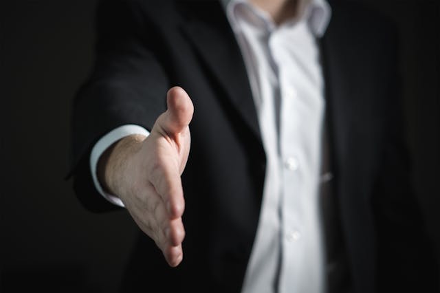 A businessman reaching out for a handshake. 