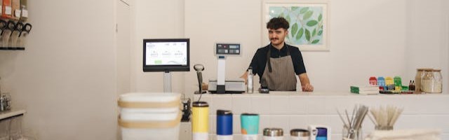 A shopkeeper behind a counter at a small business.