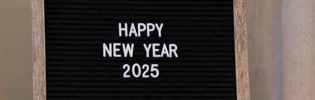 A blackboard showing the words "Happy New Year 2025"