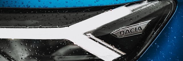 Close up of a Dacia car headlight, with branding.