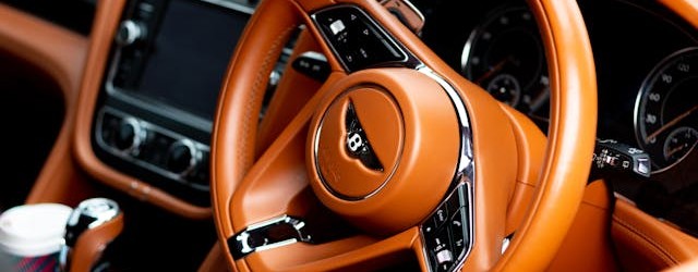 Closeup of Bentley badge on a steering wheel.