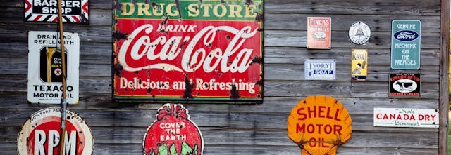 Vintage adverts on a wooden shed wall.