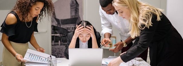 Upset business people gathered around a laptop